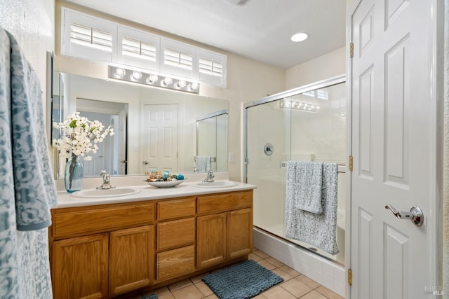 bathroom featuring a stall shower, a sink, and double vanity