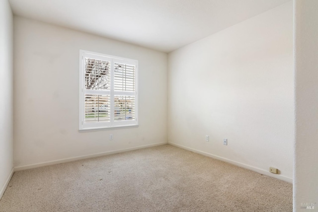 spare room featuring carpet and baseboards