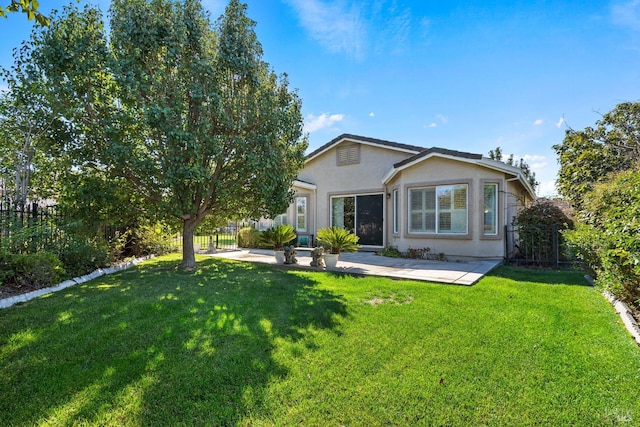 rear view of house with a patio and a yard