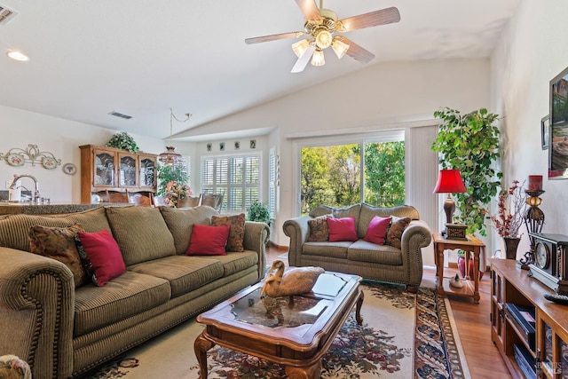 living room with lofted ceiling, ceiling fan, wood finished floors, and visible vents