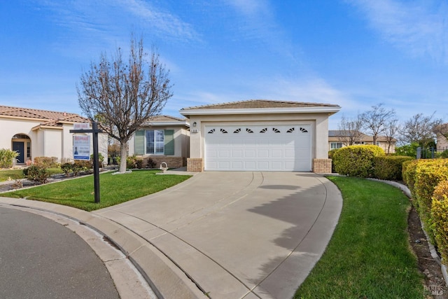 view of front of property featuring a garage, driveway, brick siding, and a front lawn