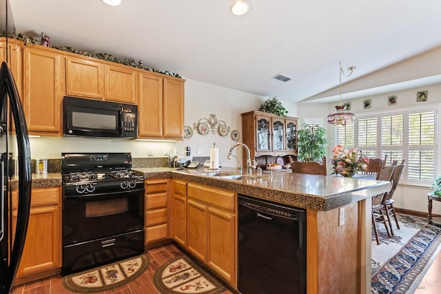 kitchen featuring visible vents, lofted ceiling, a peninsula, black appliances, and a sink