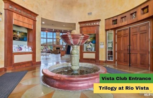 foyer with a towering ceiling and tile patterned floors