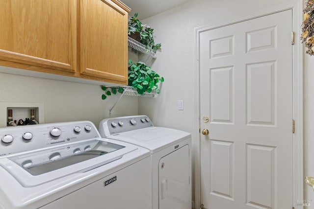 clothes washing area featuring cabinet space and separate washer and dryer