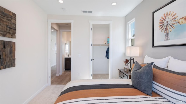 bedroom featuring light colored carpet, a closet, and a baseboard heating unit