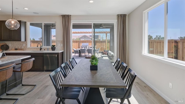 dining area featuring sink, a healthy amount of sunlight, and light hardwood / wood-style floors