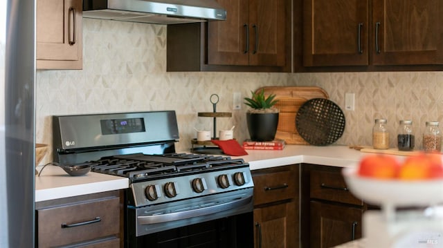 kitchen featuring decorative backsplash, dark brown cabinets, extractor fan, and appliances with stainless steel finishes