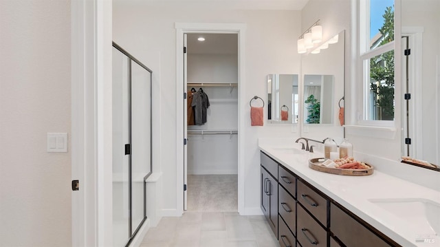 bathroom featuring a shower with door and vanity