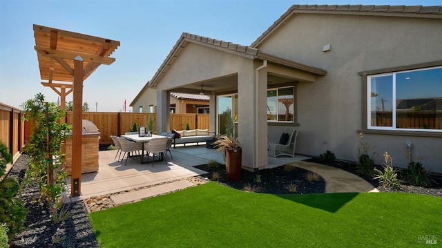 rear view of property featuring outdoor lounge area, a yard, and a patio