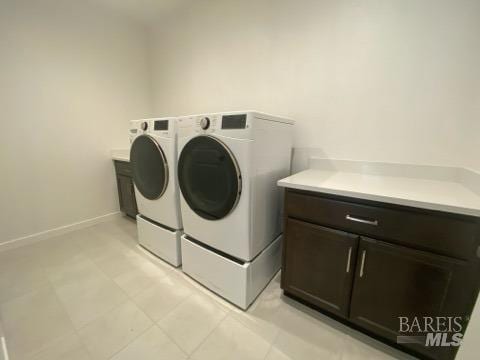 laundry area with washer and clothes dryer and cabinets