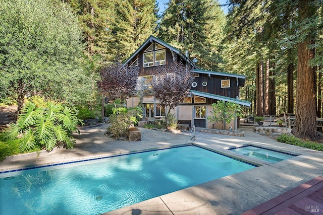 view of swimming pool featuring an in ground hot tub and a patio area