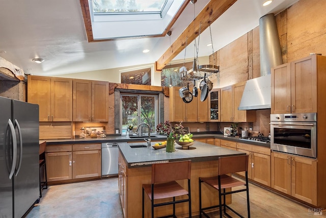 kitchen featuring a breakfast bar, vaulted ceiling with skylight, a kitchen island with sink, sink, and appliances with stainless steel finishes