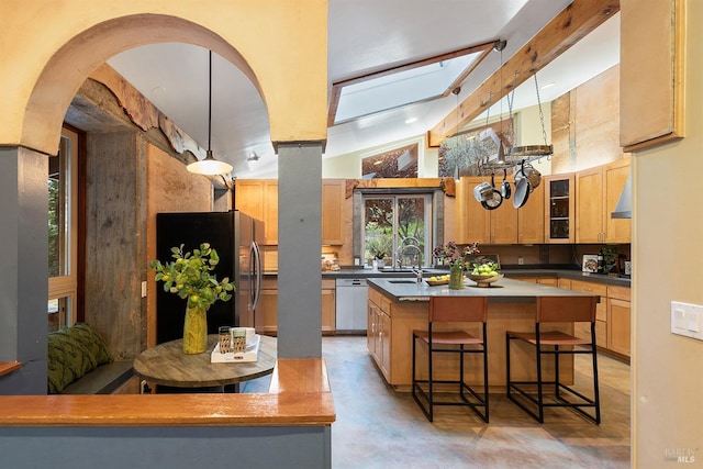 kitchen featuring a center island, stainless steel refrigerator with ice dispenser, hanging light fixtures, a skylight, and dishwashing machine