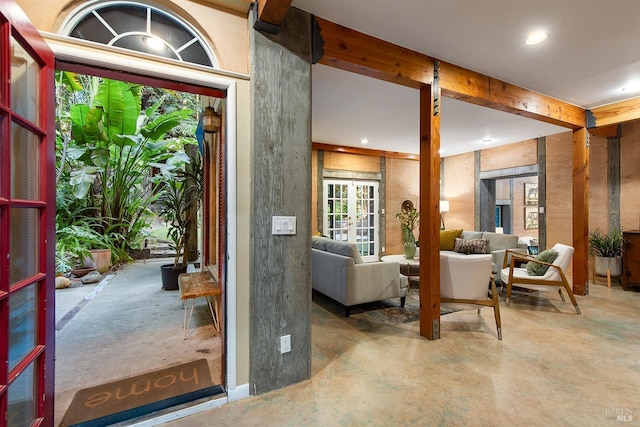 foyer featuring beamed ceiling and concrete flooring