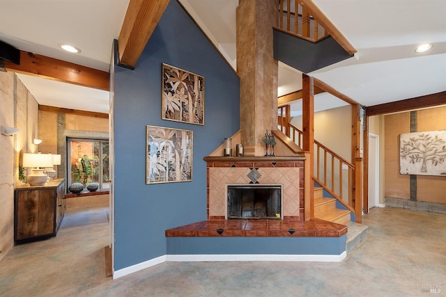 living room featuring beamed ceiling and a tiled fireplace