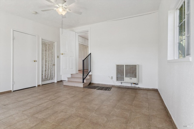 empty room with heating unit and ceiling fan