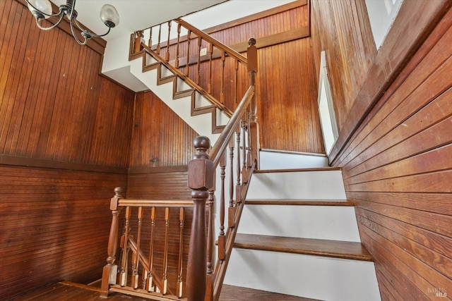 stairway with a skylight, hardwood / wood-style flooring, and wood walls