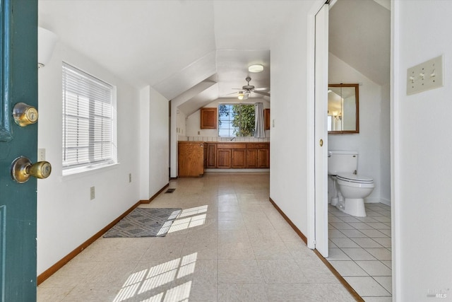 bathroom with lofted ceiling, toilet, ceiling fan, and a wealth of natural light