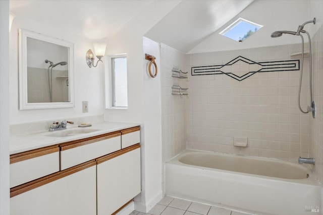 bathroom with tiled shower / bath combo, tile patterned flooring, vanity, and a skylight