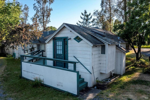 view of property exterior with a deck and a yard