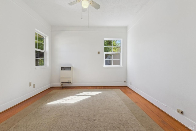 unfurnished room featuring heating unit, a textured ceiling, hardwood / wood-style floors, crown molding, and ceiling fan