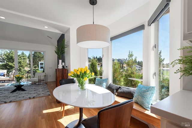 dining space featuring hardwood / wood-style flooring and vaulted ceiling