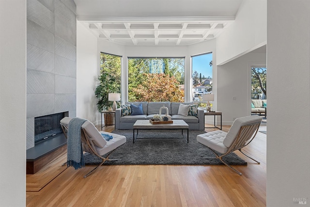 sunroom featuring beamed ceiling, coffered ceiling, and a tiled fireplace