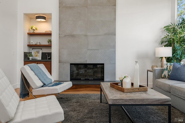 living room with hardwood / wood-style flooring and a tiled fireplace