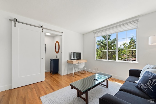 living room featuring a barn door and light hardwood / wood-style floors