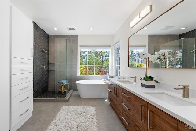 bathroom featuring shower with separate bathtub, vanity, and tile patterned floors