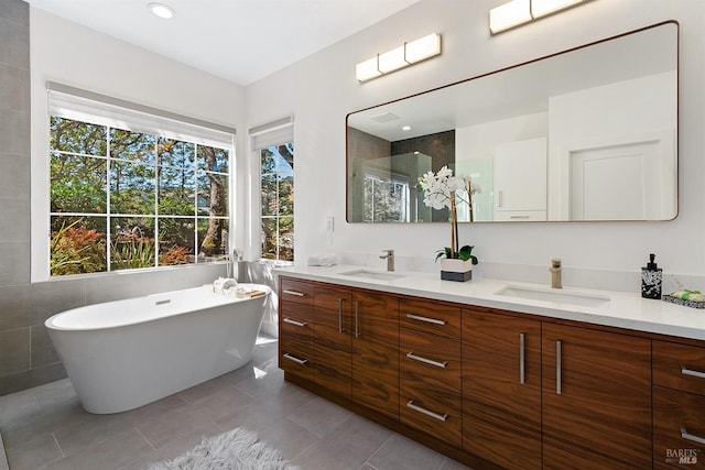 bathroom with vanity, tile patterned flooring, and a washtub