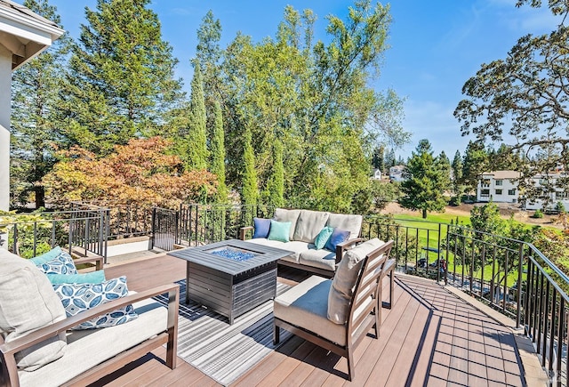 deck with an outdoor living space with a fire pit