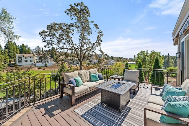 wooden terrace featuring an outdoor living space with a fire pit