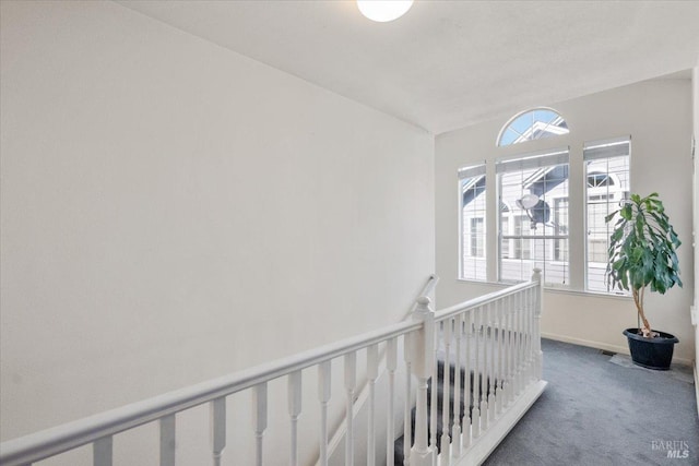 hallway with dark colored carpet