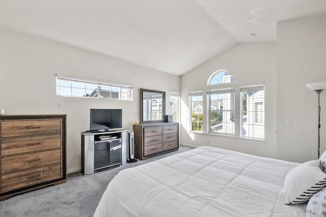 bedroom featuring light colored carpet, vaulted ceiling, and multiple windows