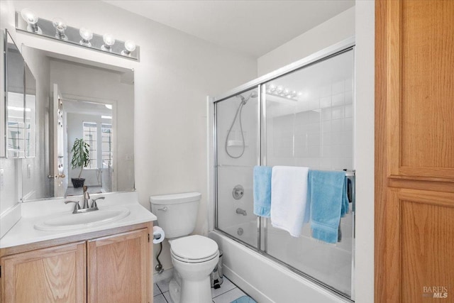 full bathroom featuring tile patterned flooring, toilet, vanity, and bath / shower combo with glass door