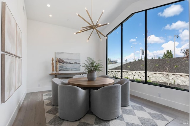 dining space featuring wood-type flooring and a notable chandelier