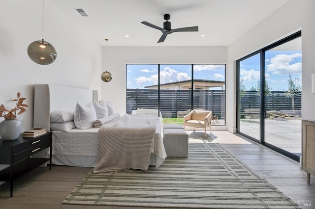 bedroom with ceiling fan, hardwood / wood-style flooring, access to exterior, and multiple windows