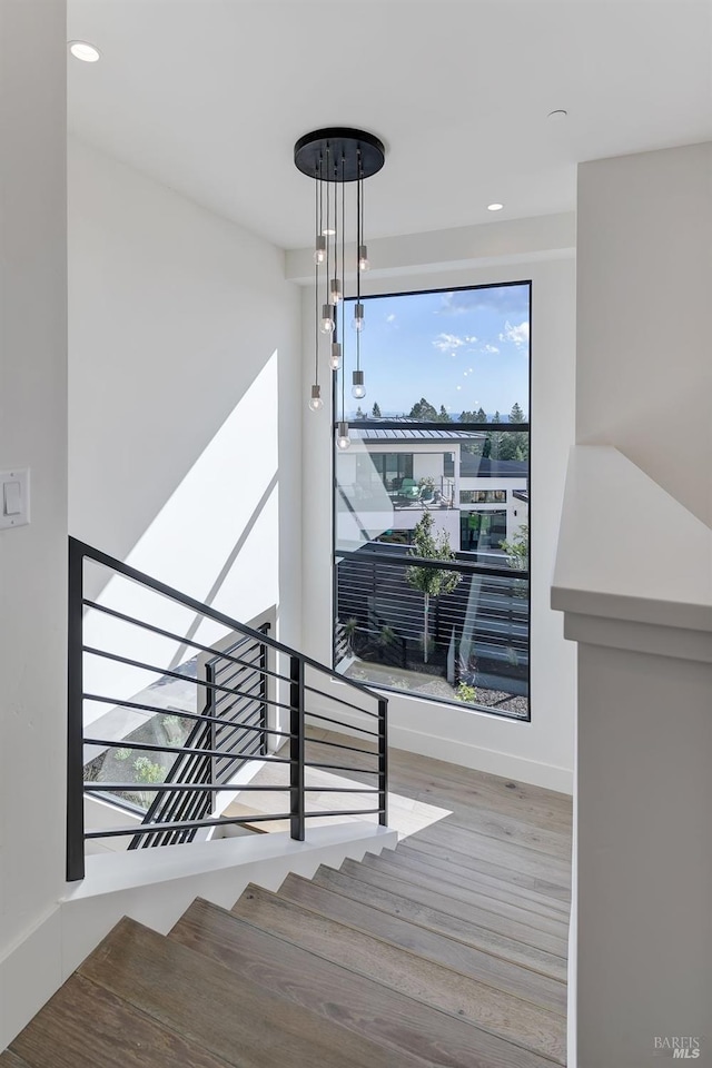 stairs with a notable chandelier and wood-type flooring