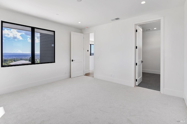 unfurnished bedroom with ensuite bath and dark colored carpet