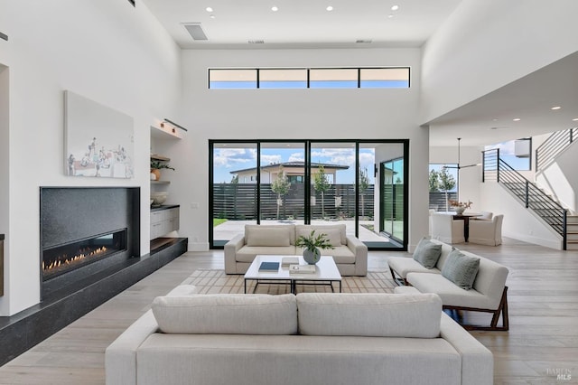 living room featuring a high ceiling and light hardwood / wood-style floors