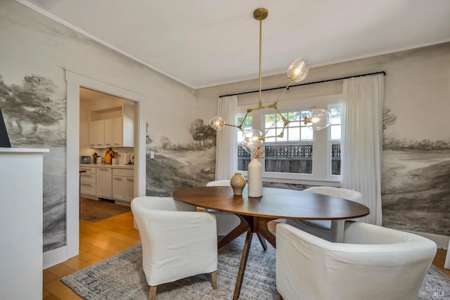 dining room with crown molding and light hardwood / wood-style floors