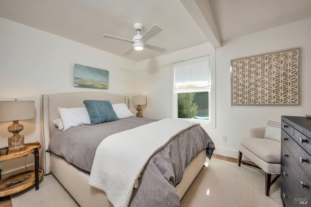 bedroom featuring beam ceiling, light carpet, and ceiling fan