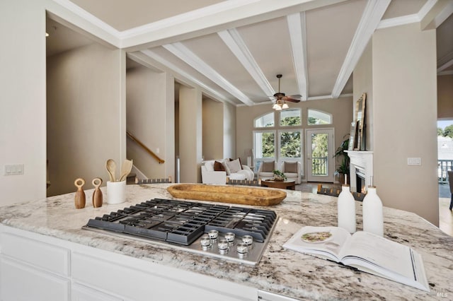 kitchen featuring stainless steel gas stovetop, white cabinetry, light stone countertops, and ceiling fan