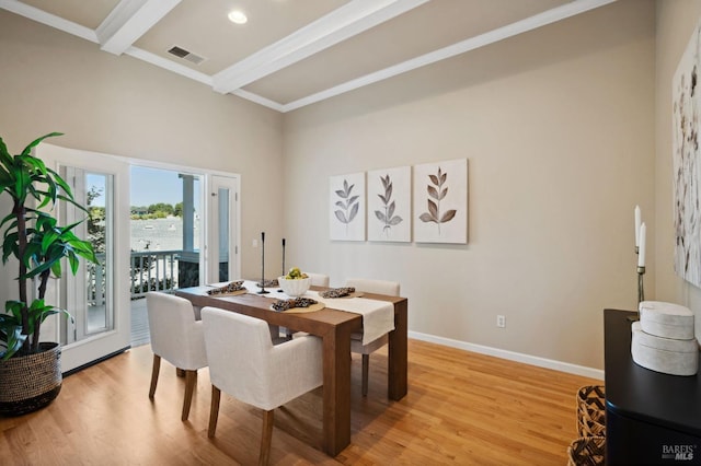 dining room featuring ornamental molding, light hardwood / wood-style floors, and beamed ceiling