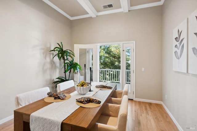 dining area with beam ceiling, light hardwood / wood-style floors, and crown molding