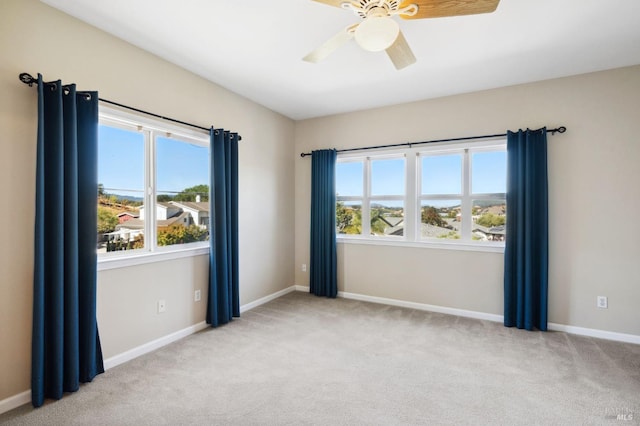 empty room featuring ceiling fan and light colored carpet