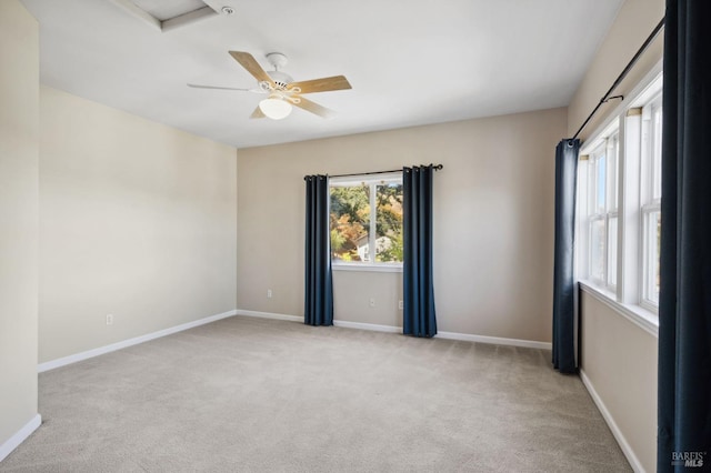 unfurnished room with ceiling fan and light carpet