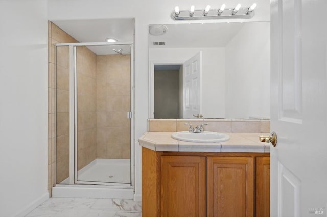 bathroom with vanity and a shower with shower door