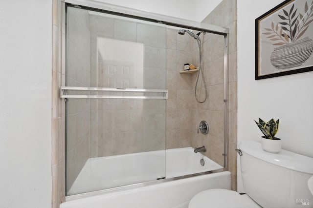 bathroom with combined bath / shower with glass door and toilet